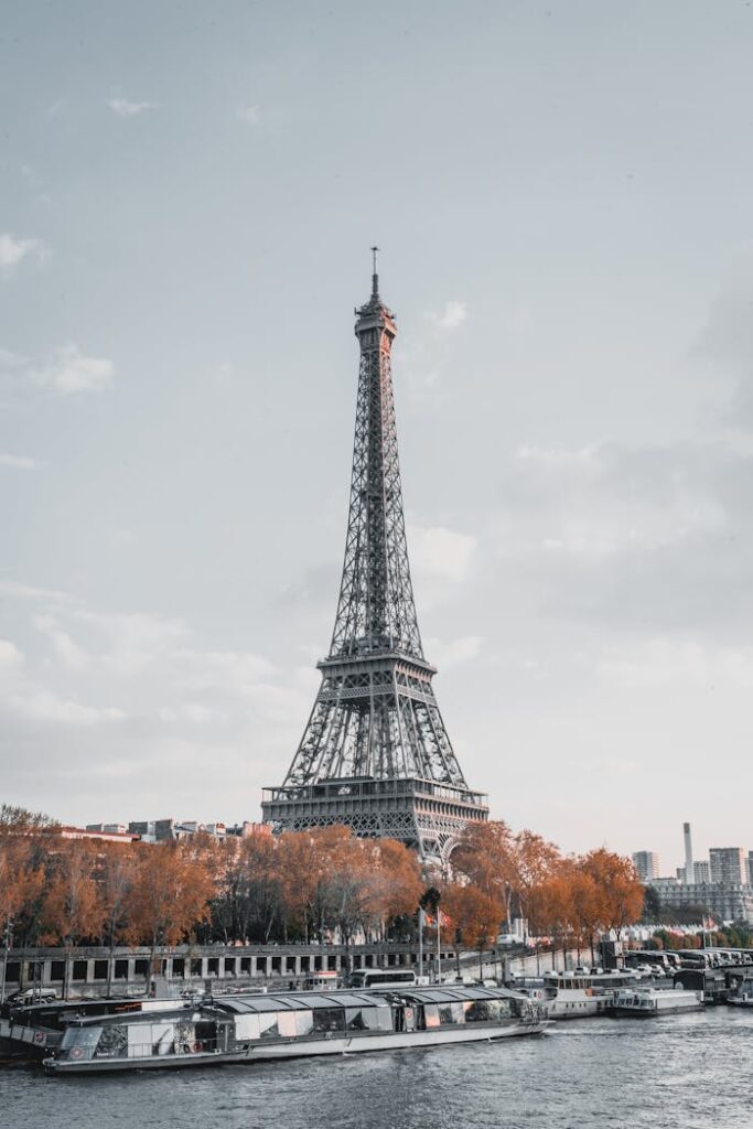 Stunning view of the Eiffel Tower in Paris with fall foliage by the Seine River.